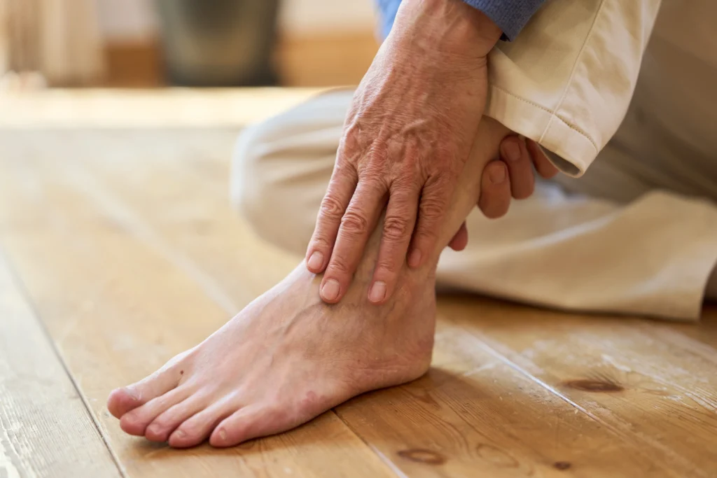 Person holding foot in pain, illustrating symptoms that lead people to search for nerve pain treatment
